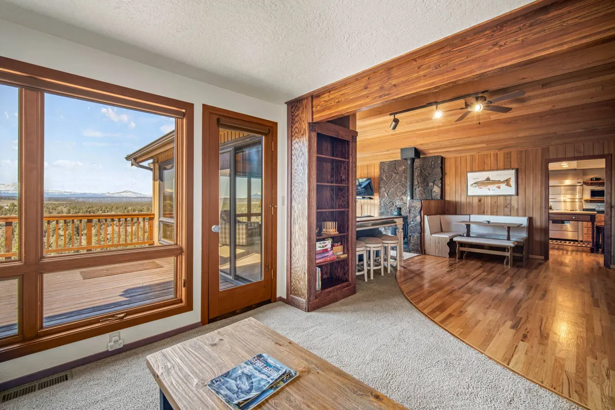 An open-plan interior with large windows, wooden finishes, and a cozy seating area. The space feels communal and flexible, making it well-suited for group activities, family gatherings, or casual tournaments after a day of adventure.